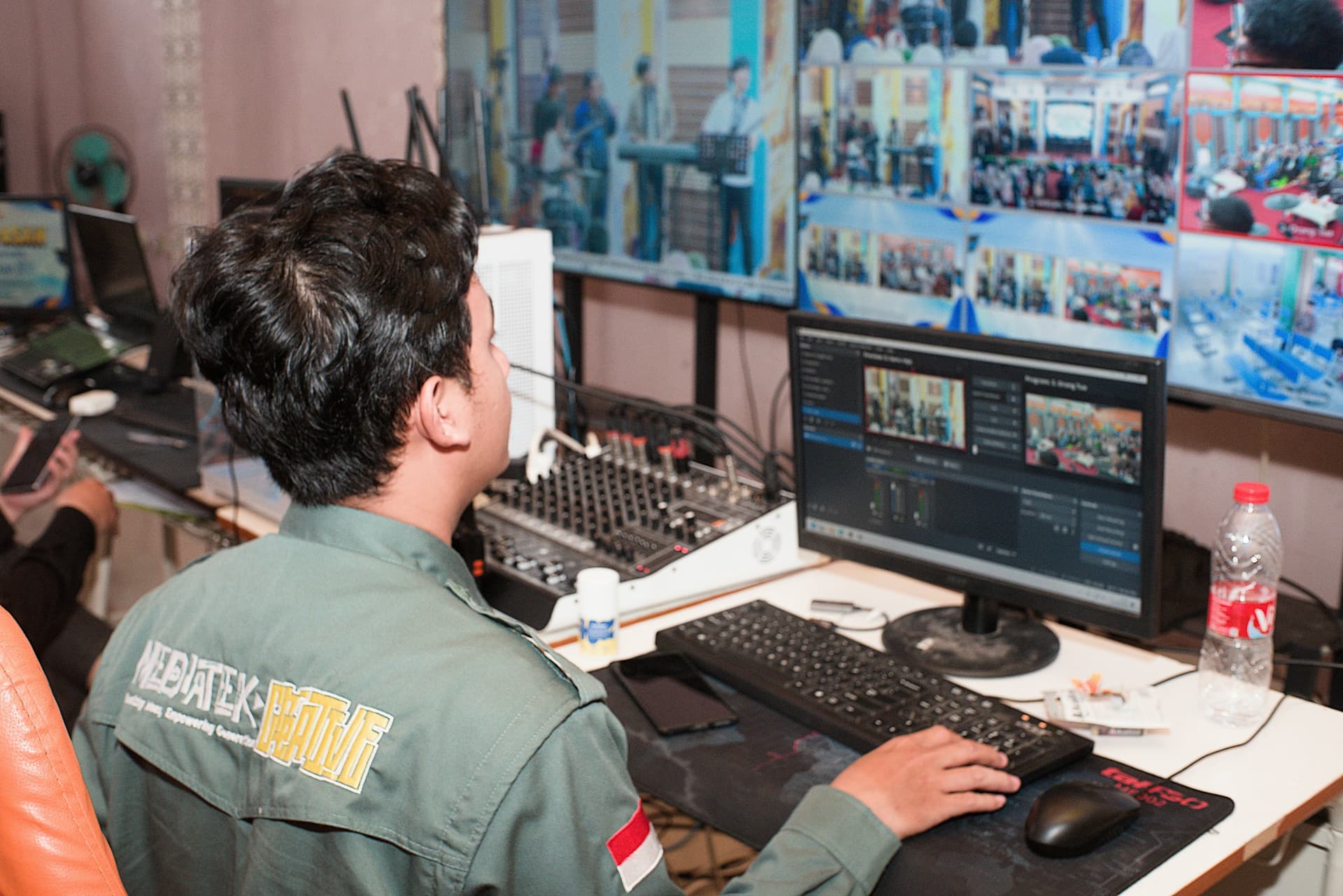 Uomo in uniforme che opera apparecchiature video e audio