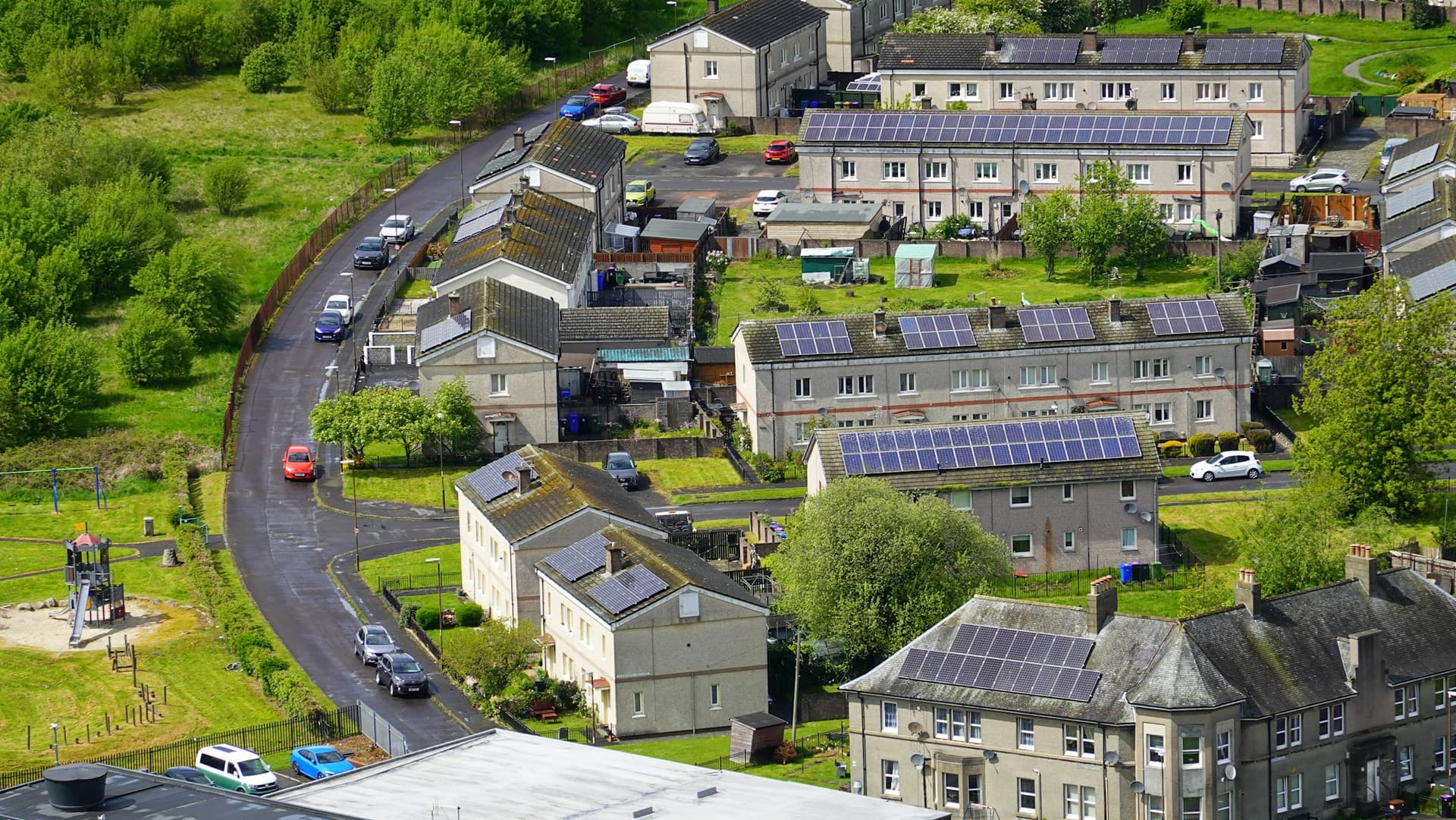 Aerial view of a residential neighbourhood with solar panels on grey rooftops