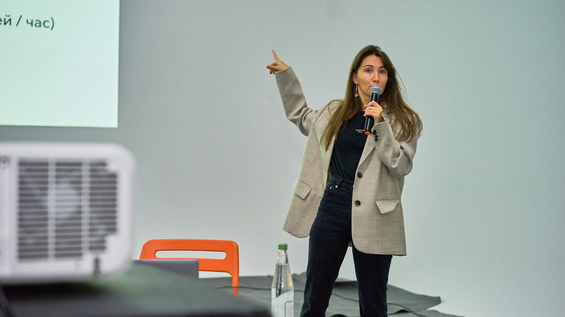Una donna in piedi davanti a uno schermo del proiettore che tiene una presentazione