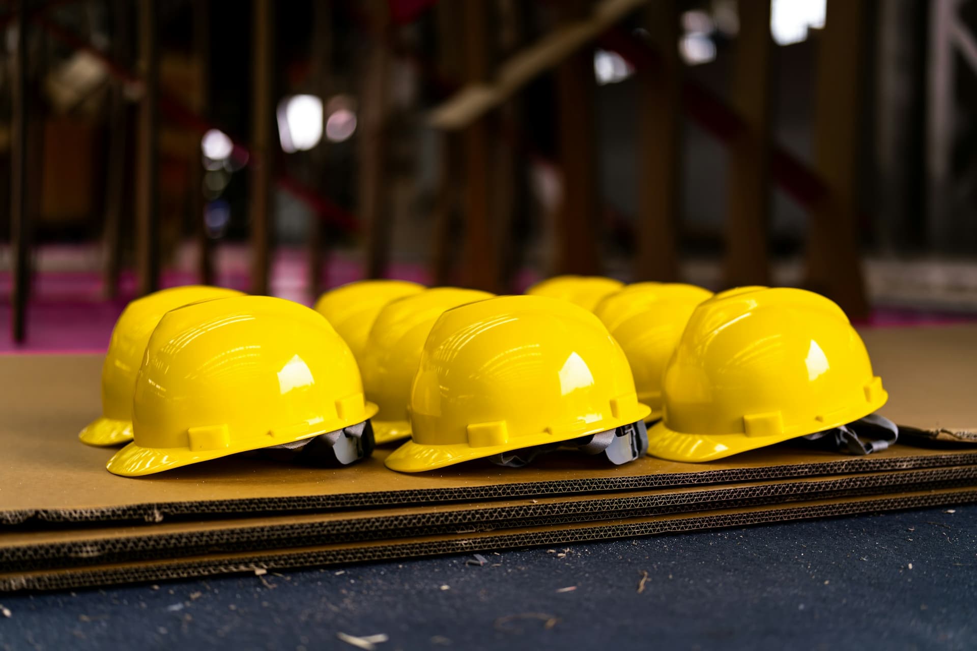 Several bright yellow hard hats neatly lined up